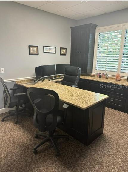 An office features a large L-shaped granite desk, dark cabinetry, and two black rolling chairs — 5245 OFFICE PARK BOULEVARD, BRADENTON, FL