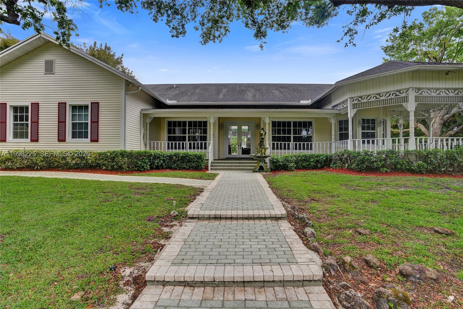 A single-story house with light yellow siding, red shutters, and a brick walkway entrance — 12350 NW 6th St, Plantation FL 33325, PLANTATION, FL