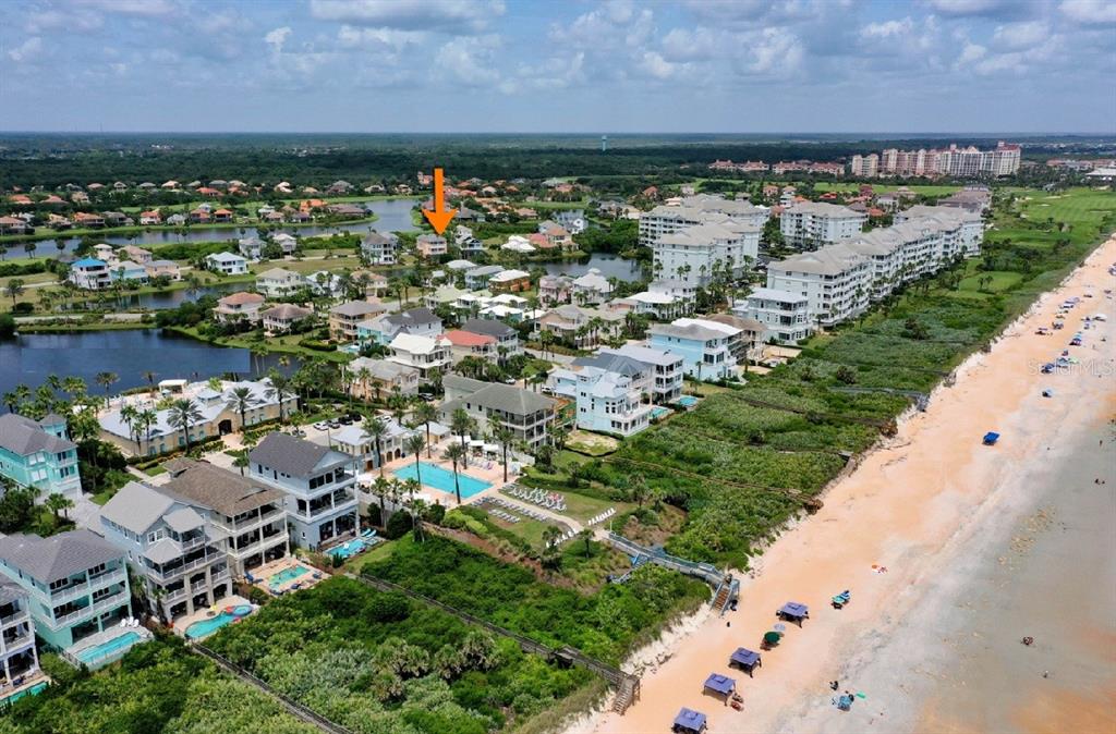 An aerial view shows a coastal neighborhood with houses, swimming pools, and a sandy beach — 39 CINNAMON BEACH WAY, PALM COAST, FL