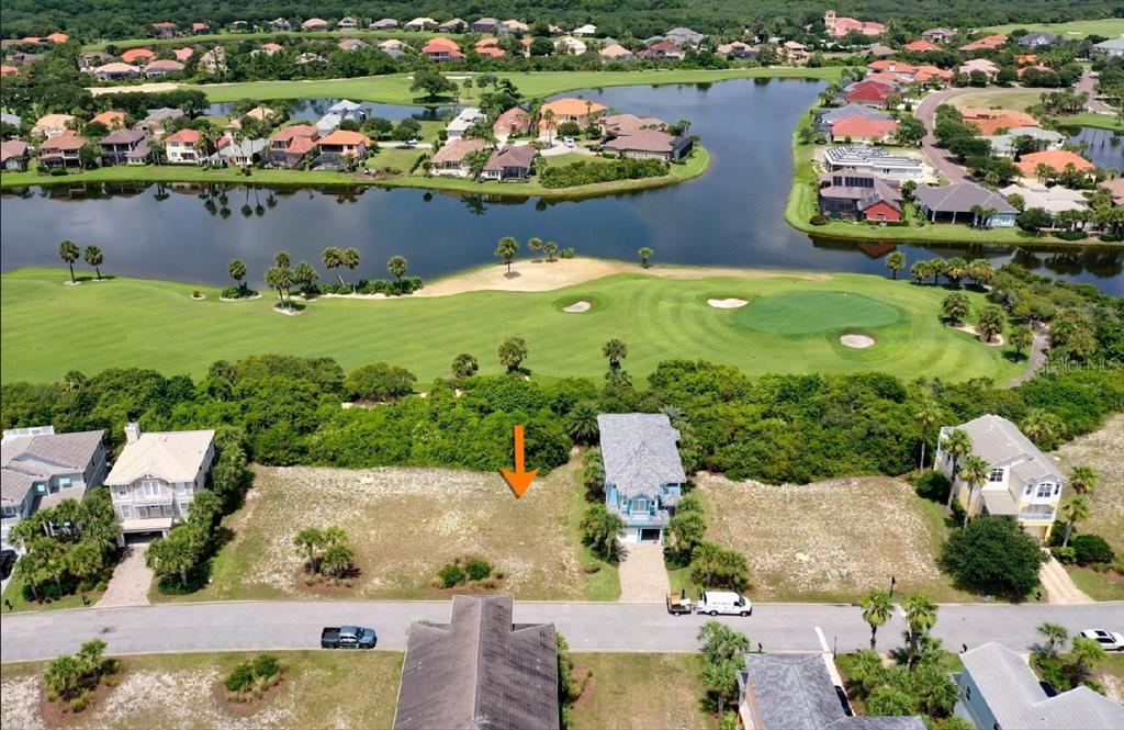 An aerial view shows a vacant residential lot situated between two houses near a golf course — 39 CINNAMON BEACH WAY, PALM COAST, FL