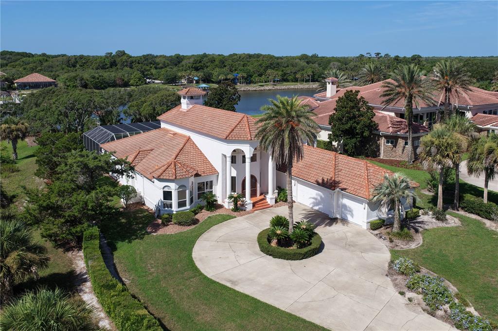 An aerial view of a white house with a tile roof and a circular driveway — 1 CAPRI COURT, PALM COAST, FL