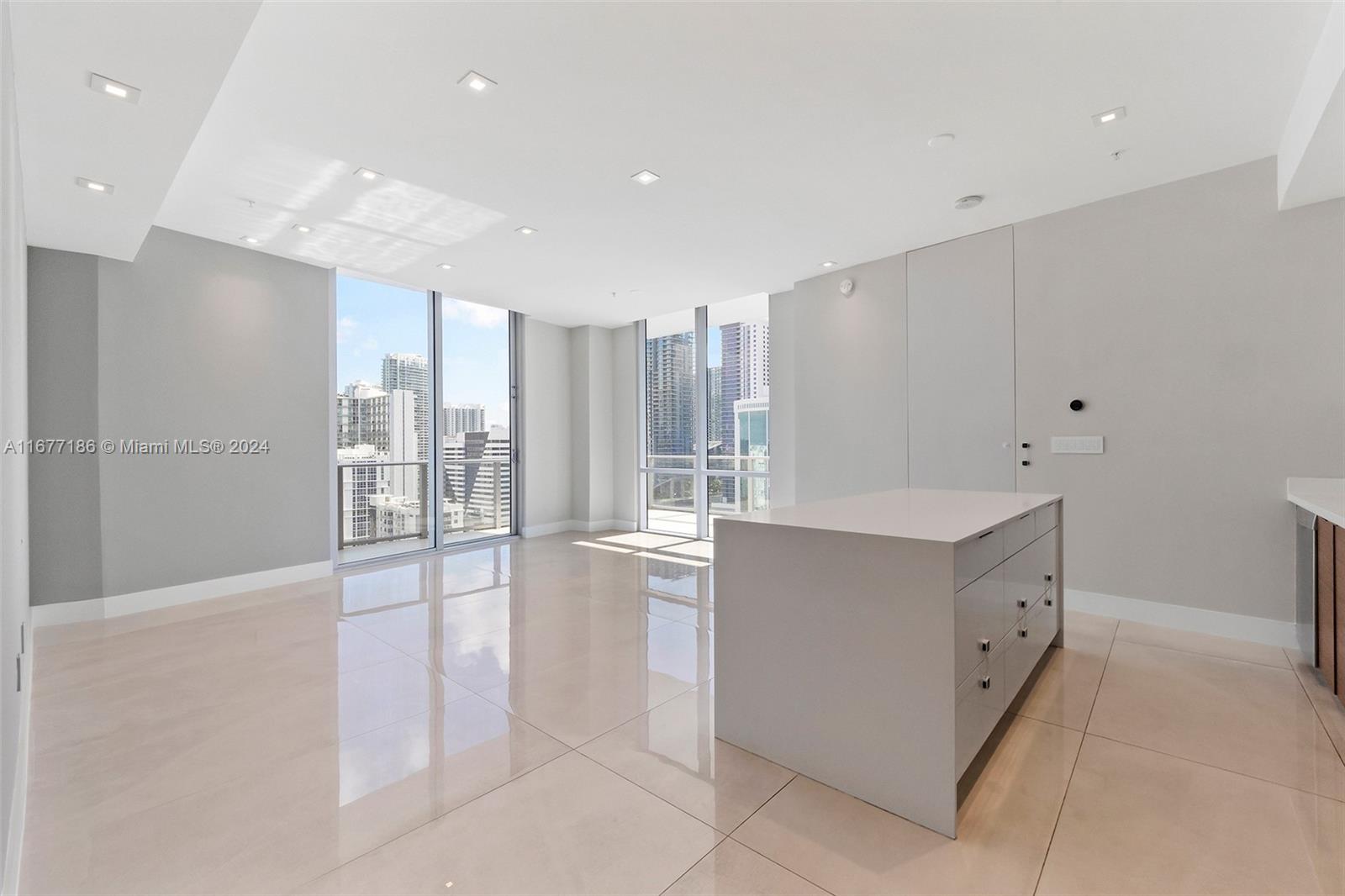 A modern kitchen island sits in a bright, open-concept room with large windows and tile floors — 1010 SW 2nd Ave, Miami FL 33130, MIAMI, FL