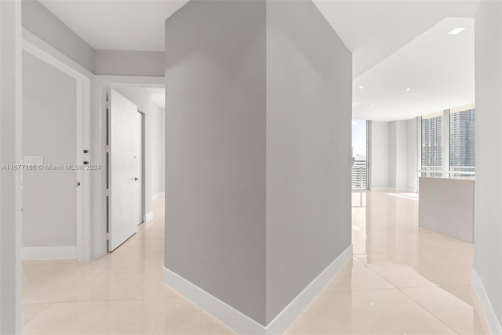 A bright hallway with light tile flooring leads to an open living area with windows — 1010 SW 2nd Ave, Miami FL 33130, MIAMI, FL