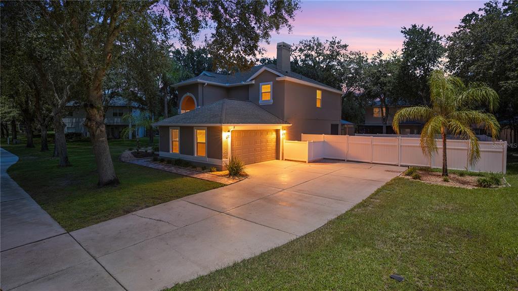A two-story house with a concrete driveway, a garage, and a white vinyl privacy fence — 1355 EDISON TREE ROAD, APOPKA, FL