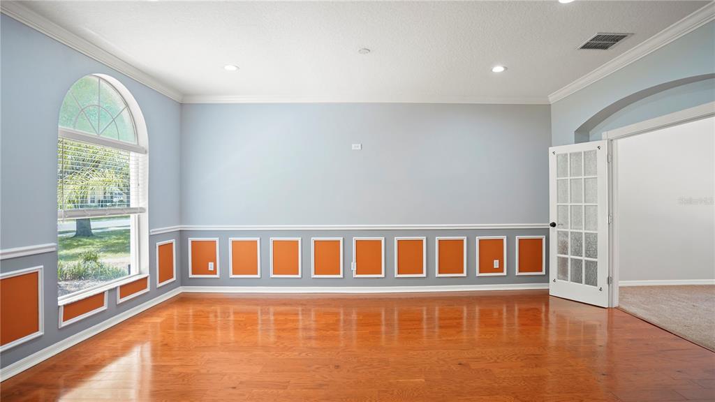 A room with hardwood floors, light blue walls, and orange wainscoting panels under a window — 1355 EDISON TREE ROAD, APOPKA, FL