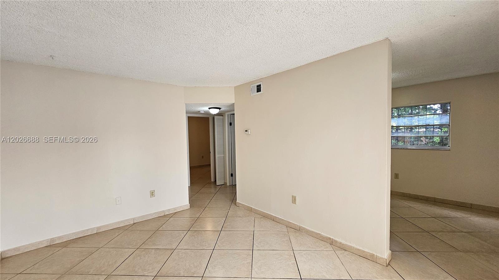 An interior view shows a tiled room with a partial wall and a window — 1235 NW 6th St # 3, Miami FL 33125, MIAMI, FL