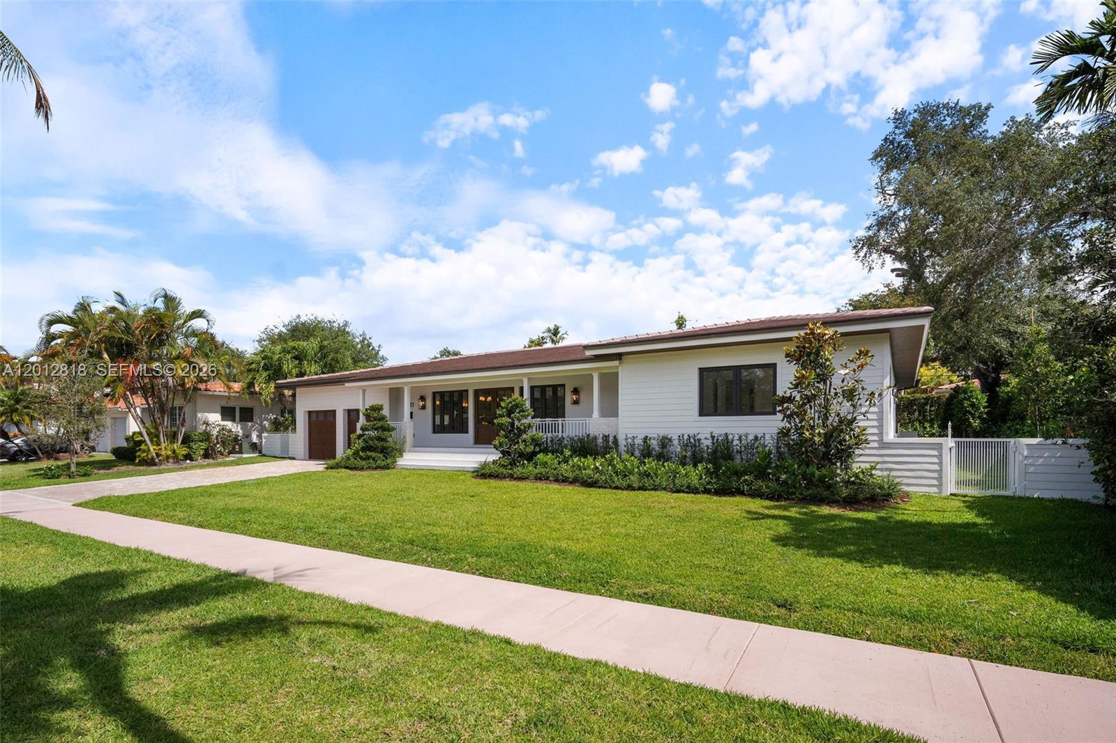 A white single-story house with a brown roof, a front lawn, and a concrete driveway — 1431 Certosa Ave, Coral Gables FL 33146, CORAL GABLES, FL
