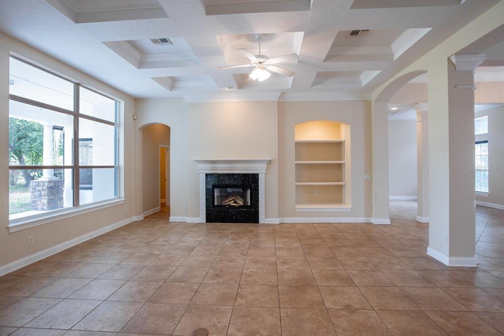 A living room features a coffered ceiling, tile floors, a fireplace, and built-in shelving — 25609 HAWKS RUN LANE, SORRENTO, FL