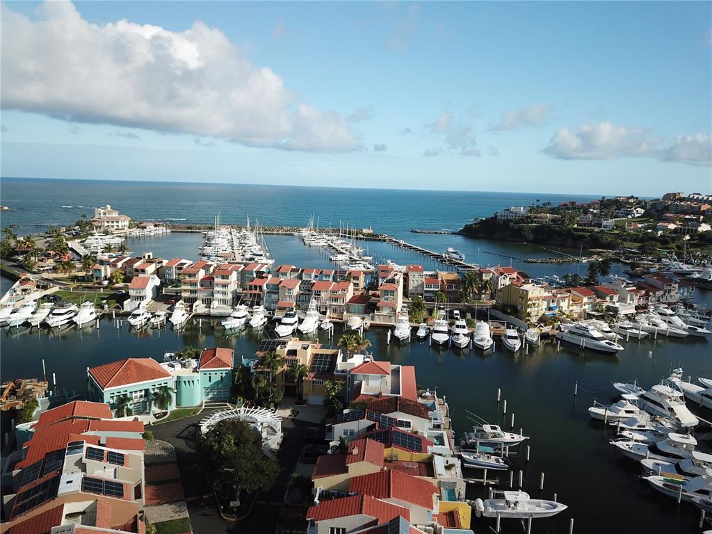 An aerial view shows a coastal residential community with a marina full of boats — SAN MIGUEL 47, HUMACAO, PR