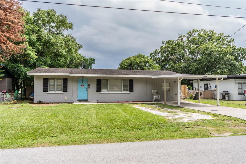 A single-story house with light gray siding, a light blue front door, and a carport — 3004 AVENUE S NW, WINTER HAVEN, FL