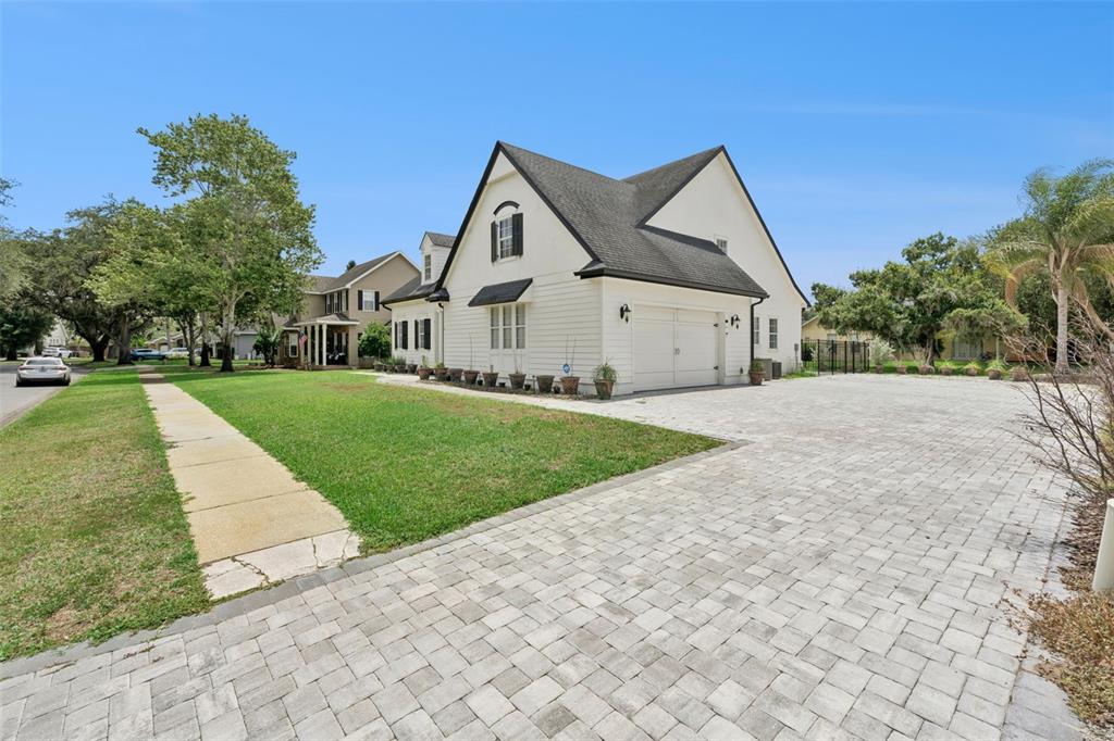 A white two-story house with a dark roof and a large paved driveway — 5210 HAMMOCK CIRCLE, ST CLOUD, FL