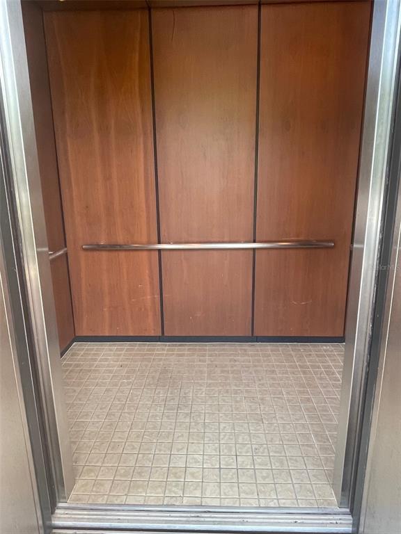An elevator interior features wood-paneled walls, a metal handrail, and a tiled floor — 6 MERIDIAN HOME LANE UNIT 101, PALM COAST, FL