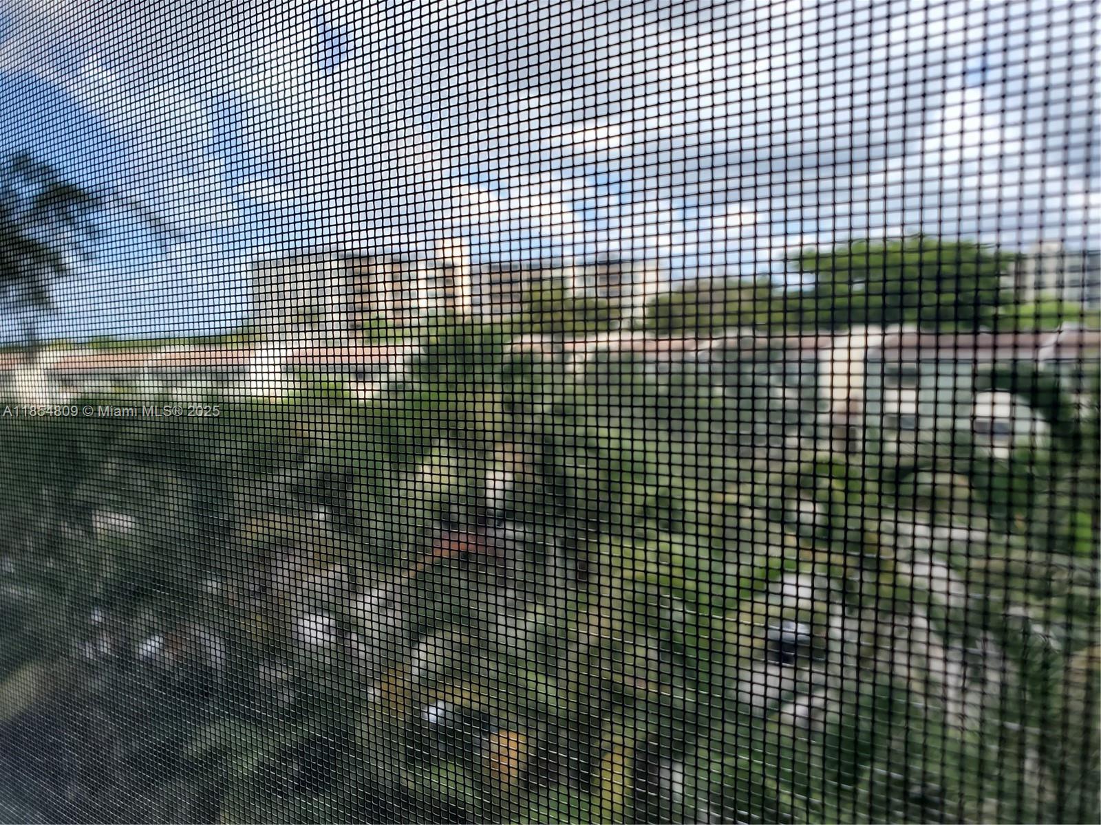 A view of a residential neighborhood seen through a black window screen — 3940 Inverrary Blvd # A, Lauderhill FL 33319, LAUDERHILL, FL