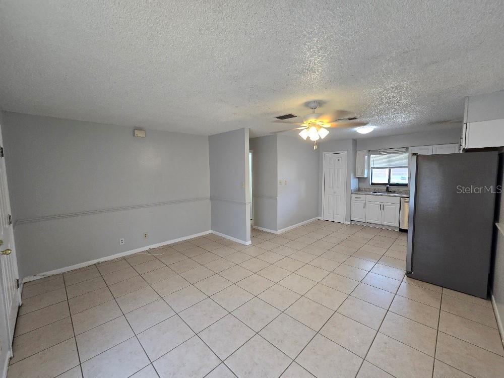 A kitchen features white cabinets, stainless steel appliances, and light-colored tile flooring — 780 E NORTH STREET, BARTOW, FL