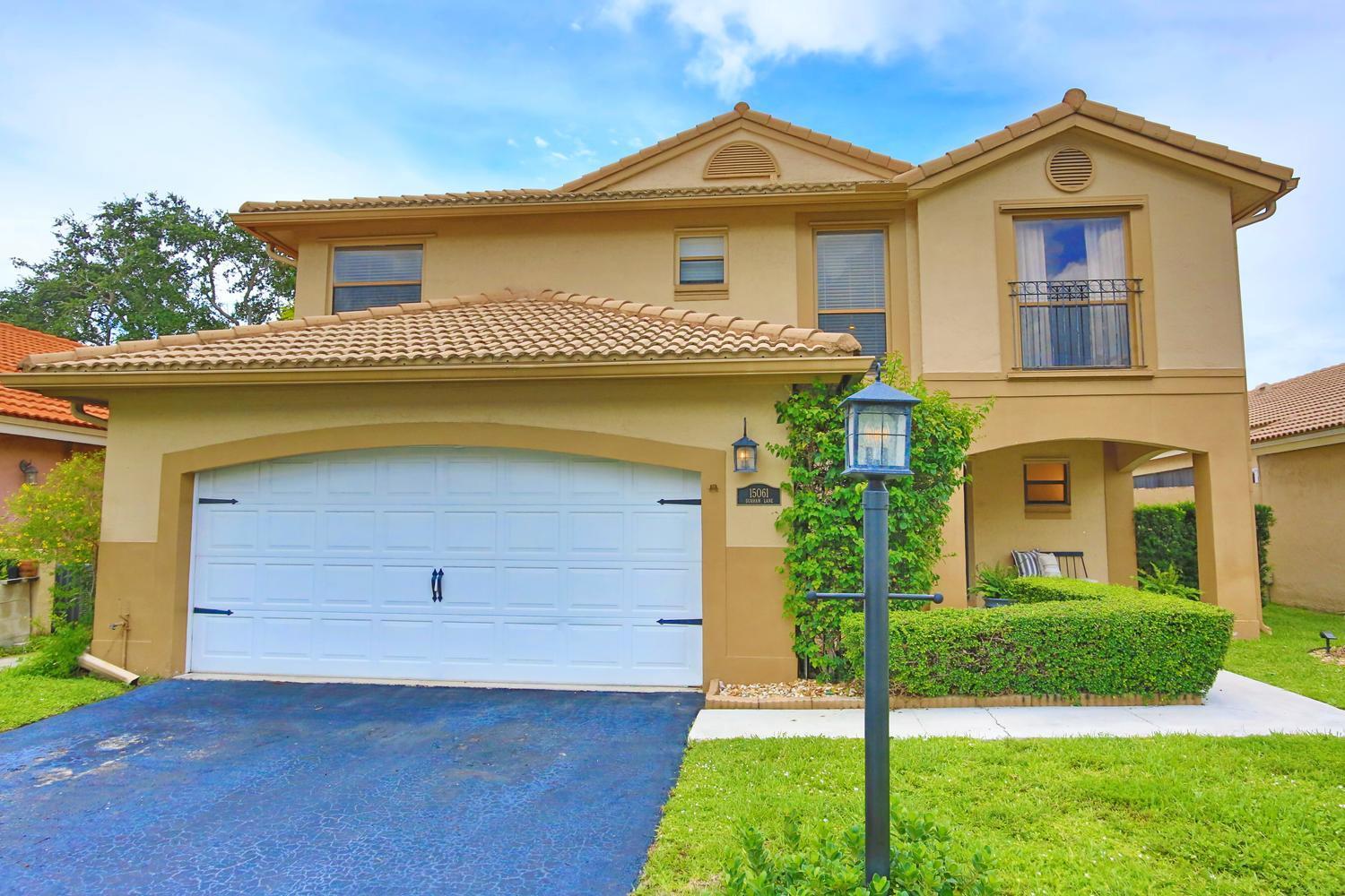A two-story house with a tan stucco exterior, a two-car garage, and a tiled roof — 15061 Durham Lane, Davie FL 33331, DAVIE, FL