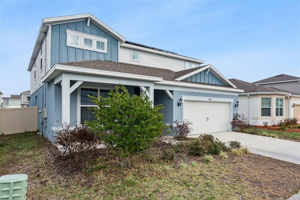 A two-story blue house with a white garage and a covered front porch — 4008 MEANDERING BAY DRIVE, APOPKA, FL