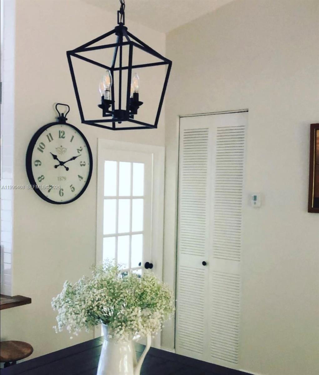 A dining area features a black lantern pendant light, a wall clock, and white doors — 11269 SW 116th Ter # 11269, Miami FL 33176, MIAMI, FL