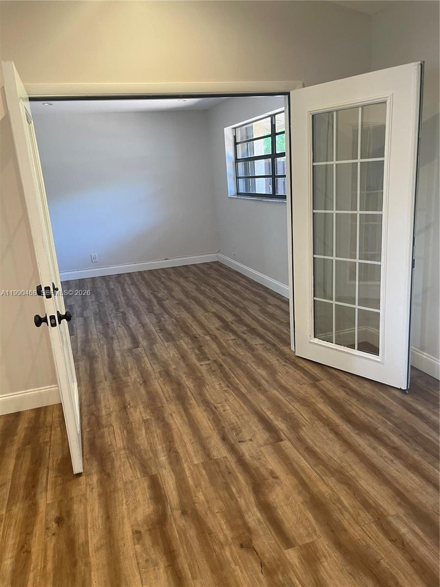 A room with wood-look flooring and French doors leading to a windowed interior space — 11269 SW 116th Ter # 11269, Miami FL 33176, MIAMI, FL