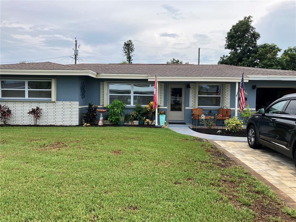 A single-story house with blue siding, white brick accents, and a paved driveway — 968 62ND PLACE S, ST PETERSBURG, FL