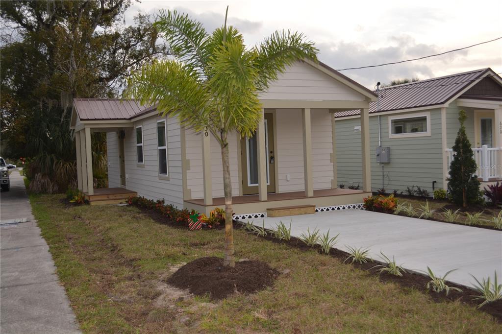 A small, light-colored house with a front porch, metal roof, and a palm tree out front — 630 THIRD STREET STREET, OVIEDO, FL