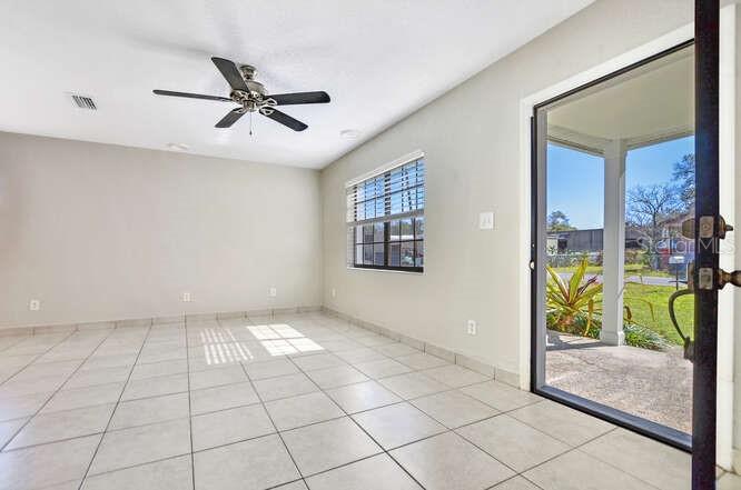A room with light-colored tile flooring, a ceiling fan, and a sliding glass door — 816 E FRIERSON AVENUE, TAMPA, FL