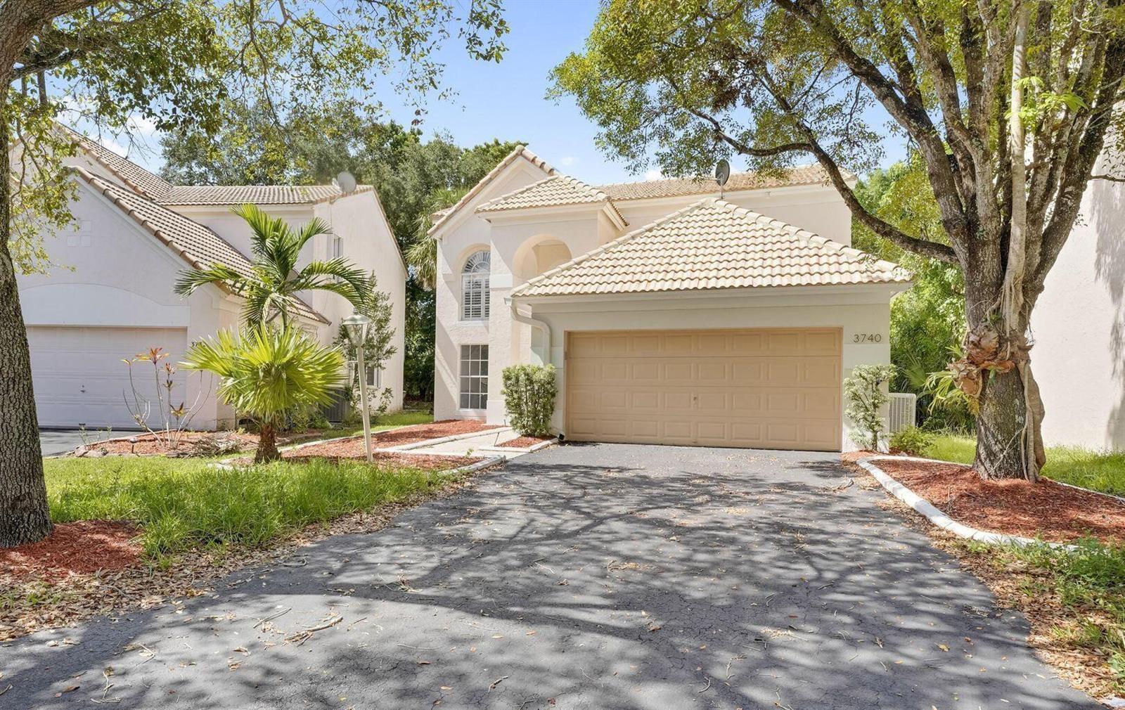 A two-story house with a tan garage door, tile roof, and a paved driveway — 3740 Wilderness Way, Coral Springs FL 33065, CORAL SPRINGS, FL