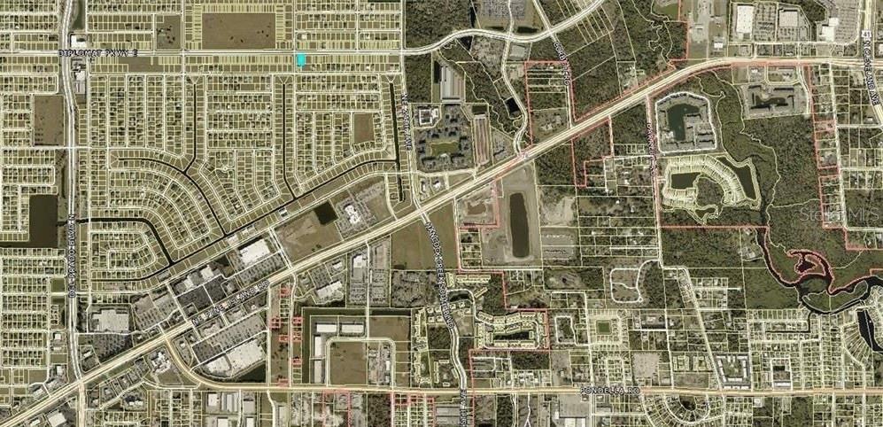 This is an aerial map showing a residential area with a highlighted property lot — 2104 DIPLOMAT PARKWAY E, CAPE CORAL, FL