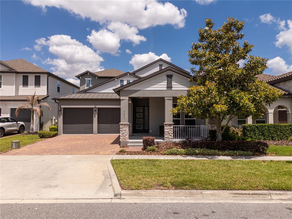A two-story suburban house features a gray exterior, a two-car garage, and a front porch — 9942 SUMMERLAKE GROVES STREET, WINTER GARDEN, FL