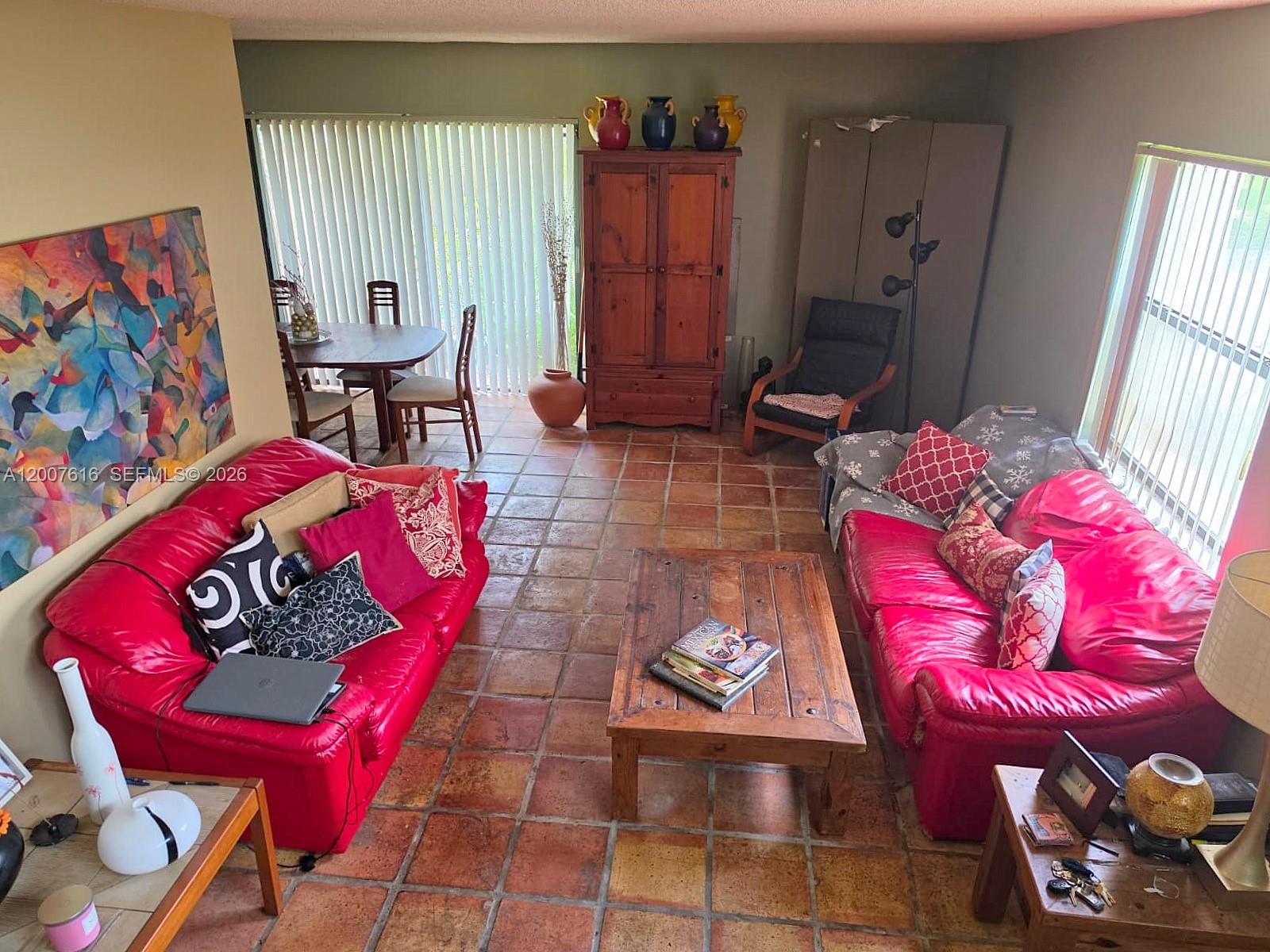 A living room features two red leather sofas, tile flooring, and a wooden coffee table — 10901 SW 113th Pl # 66B, Miami FL 33176, MIAMI, FL