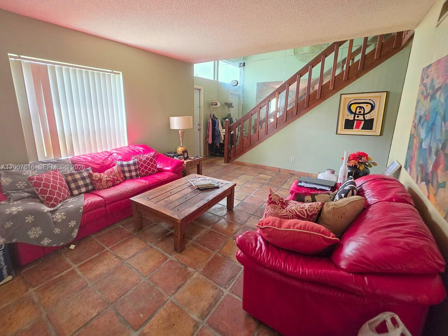 A living room features two red leather sofas, a wooden coffee table, and a staircase — 10901 SW 113th Pl # 66B, Miami FL 33176, MIAMI, FL