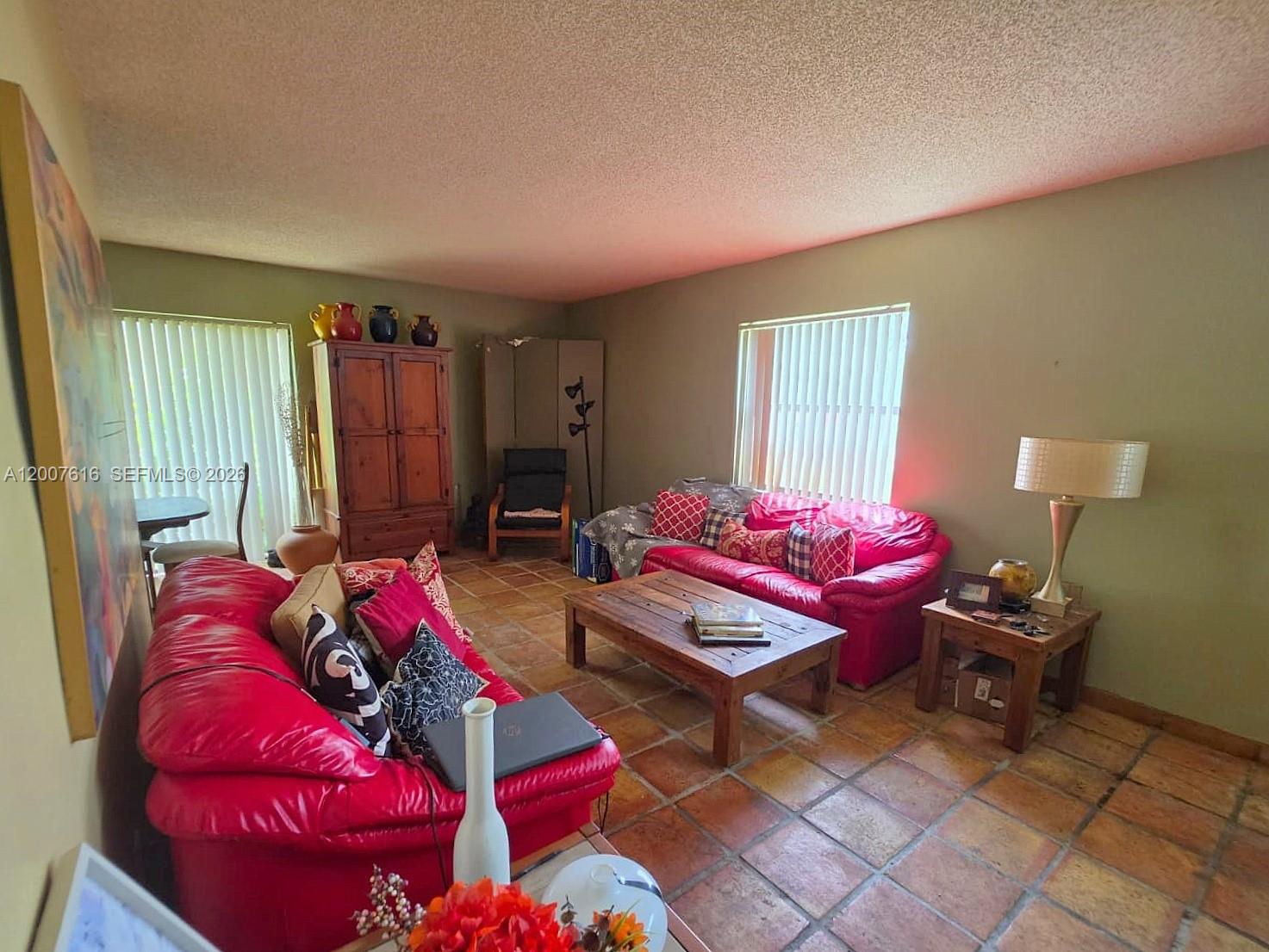 A living room features red leather sofas, a wooden coffee table, and tile flooring — 10901 SW 113th Pl # 66B, Miami FL 33176, MIAMI, FL