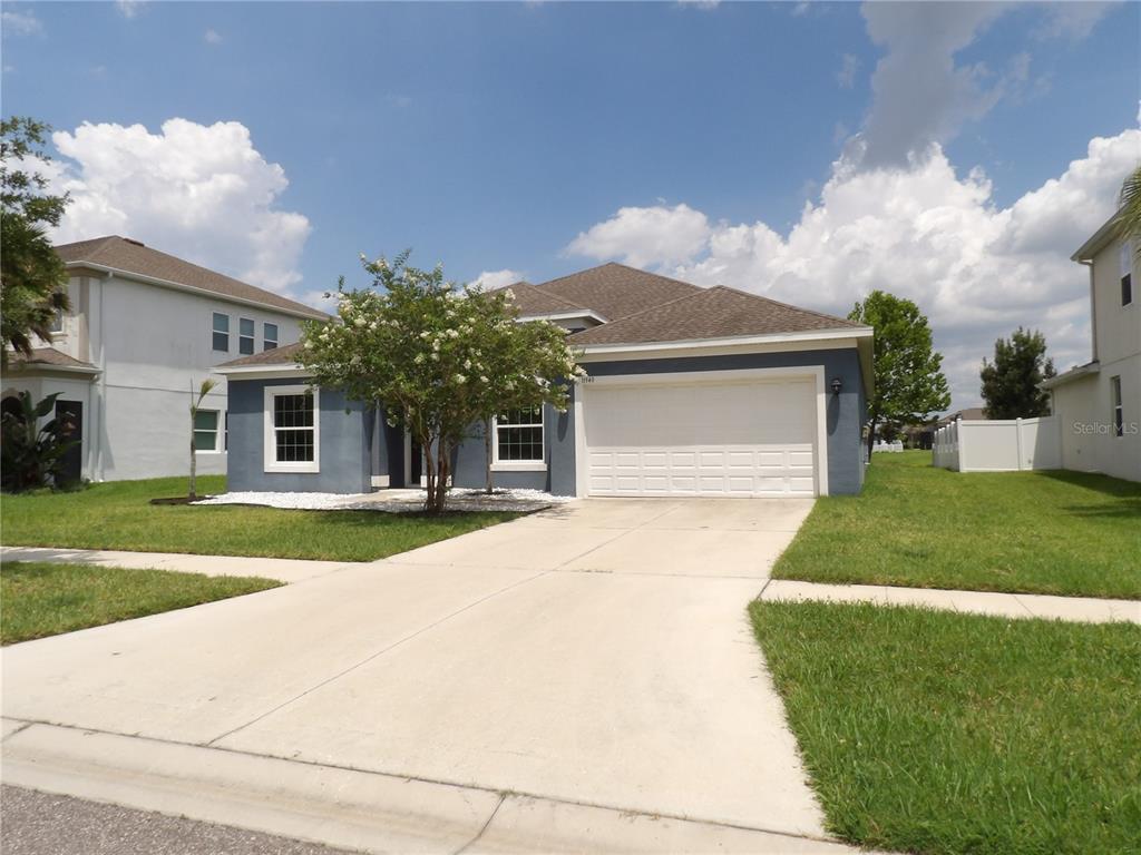 A blue single-story house with a white garage door and a concrete driveway — 11940 SUNBURST MARBLE ROAD, RIVERVIEW, FL