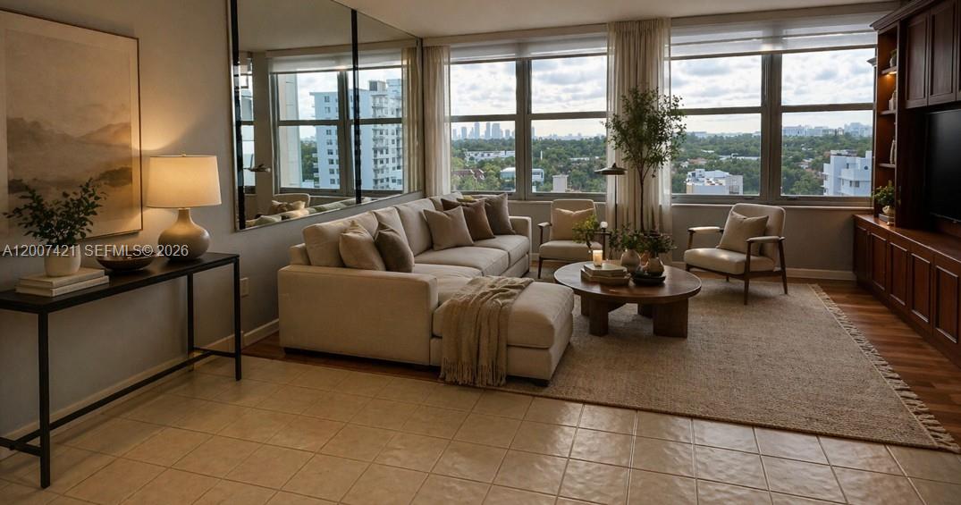 A living room features a beige sectional sofa, a round coffee table, and large windows — 2899 Collins Ave # 1040, Miami Beach FL 33140, MIAMI BEACH, FL