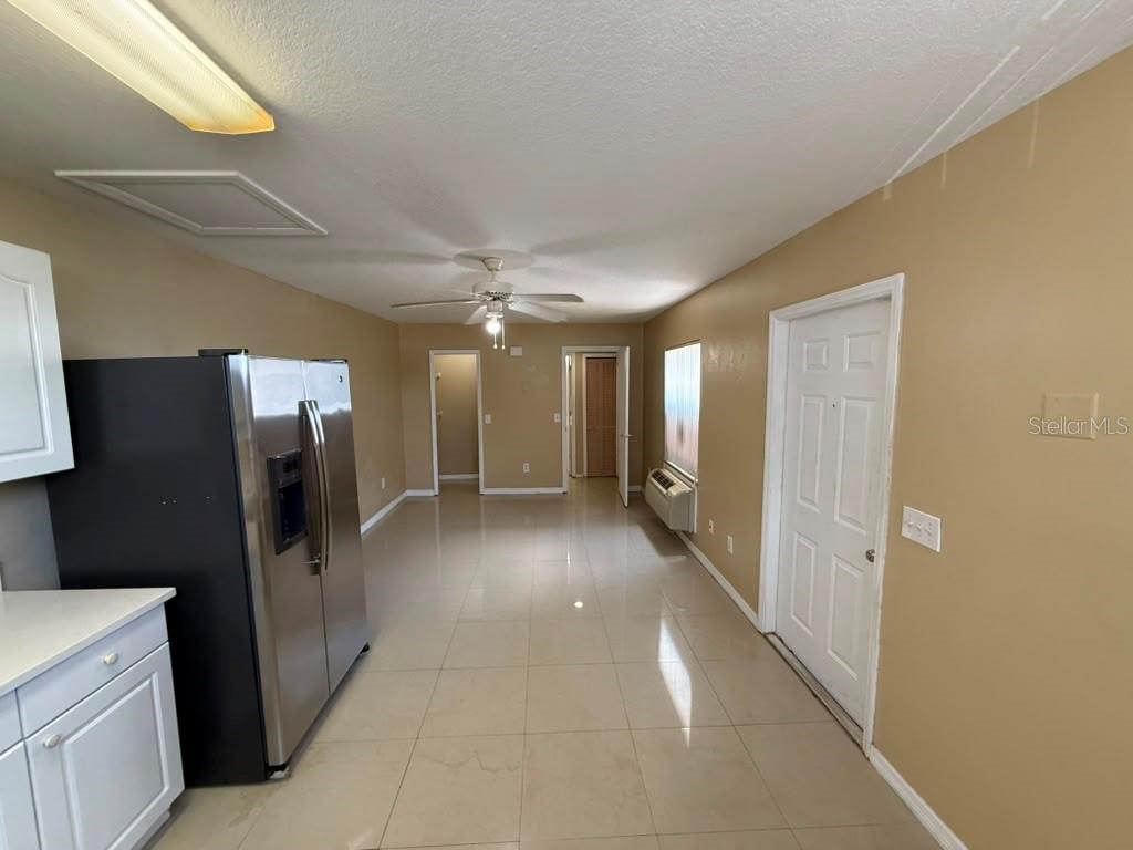 A kitchen with light tile floors, white cabinets, a black refrigerator, and a ceiling fan — 709 ORCHID DRIVE UNIT B, DAVENPORT, FL