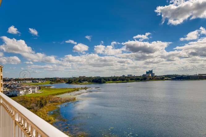 An elevated view of a lake with houses on the shore and a distant Ferris wheel — 8749 THE ESPLANADE UNIT 32, ORLANDO, FL