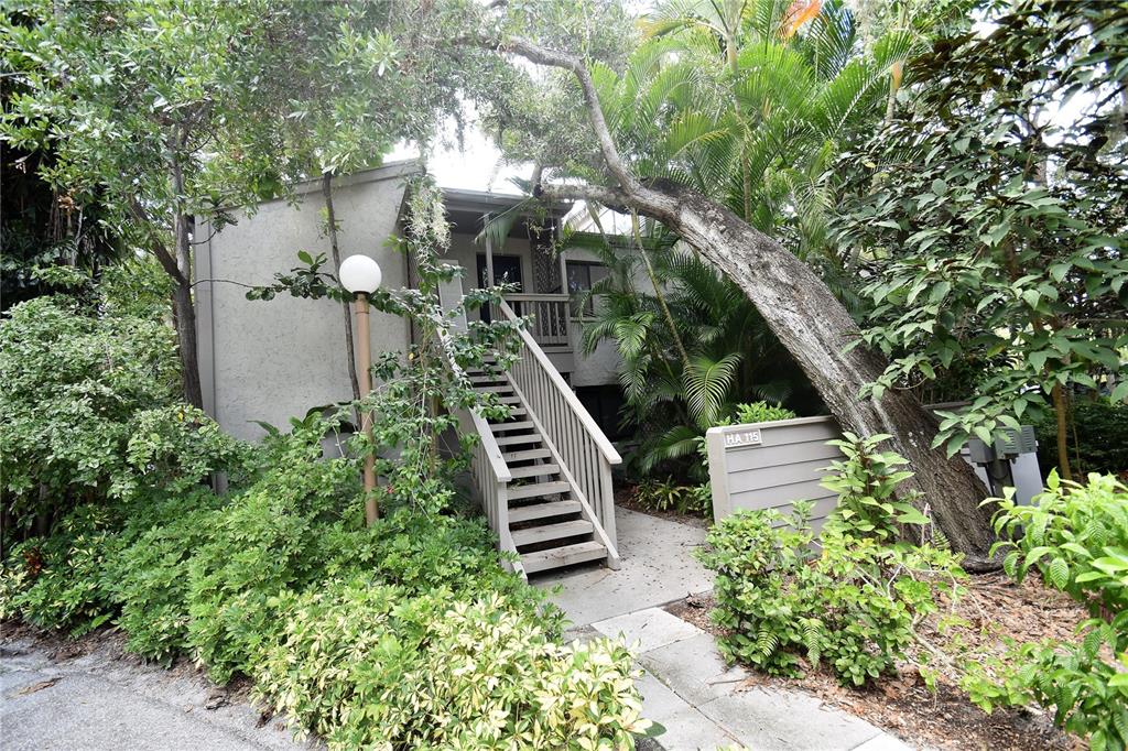 A kitchen features light wood cabinets, granite countertops, black appliances, and a stainless steel dishwasher — 1601 PELICAN POINT DRIVE UNIT HA215, SARASOTA, FL