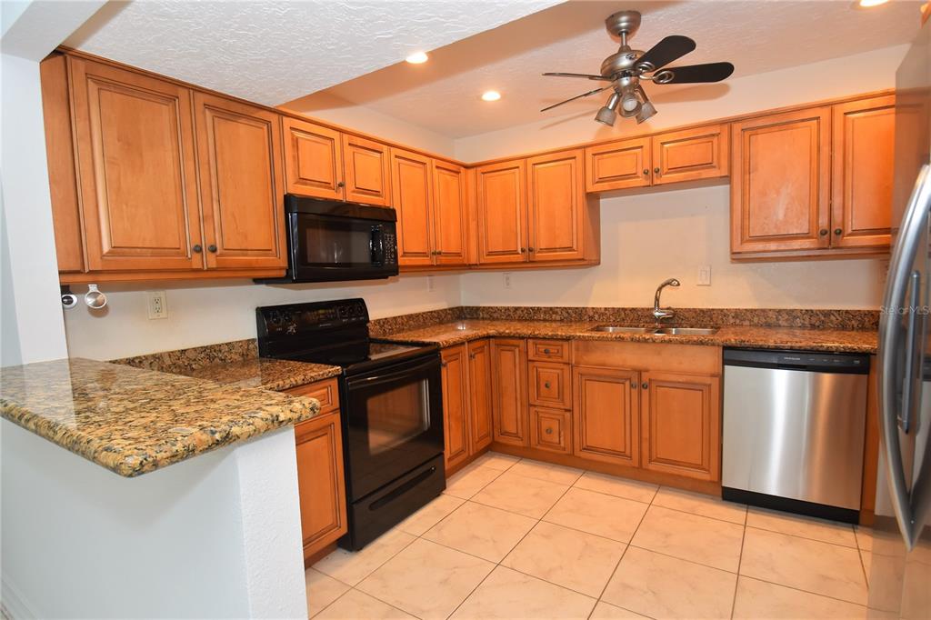 A room with vaulted ceilings, a ceiling fan, tiled floors, and louvered closet doors — 1601 PELICAN POINT DRIVE UNIT HA215, SARASOTA, FL