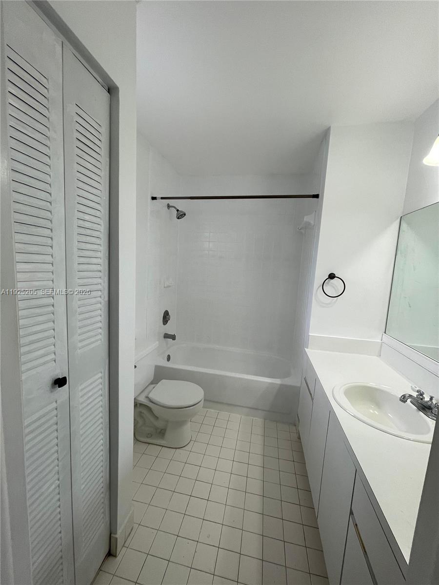 A bathroom features a white vanity, a toilet, and a bathtub with a shower head — 3375 W 76th St # 211, Hialeah FL 33018, HIALEAH, FL
