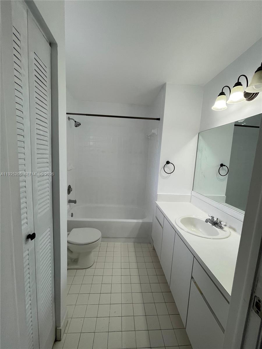 A bathroom features a white vanity, a toilet, and a shower-tub combination with white tile — 3375 W 76th St # 211, Hialeah FL 33018, HIALEAH, FL