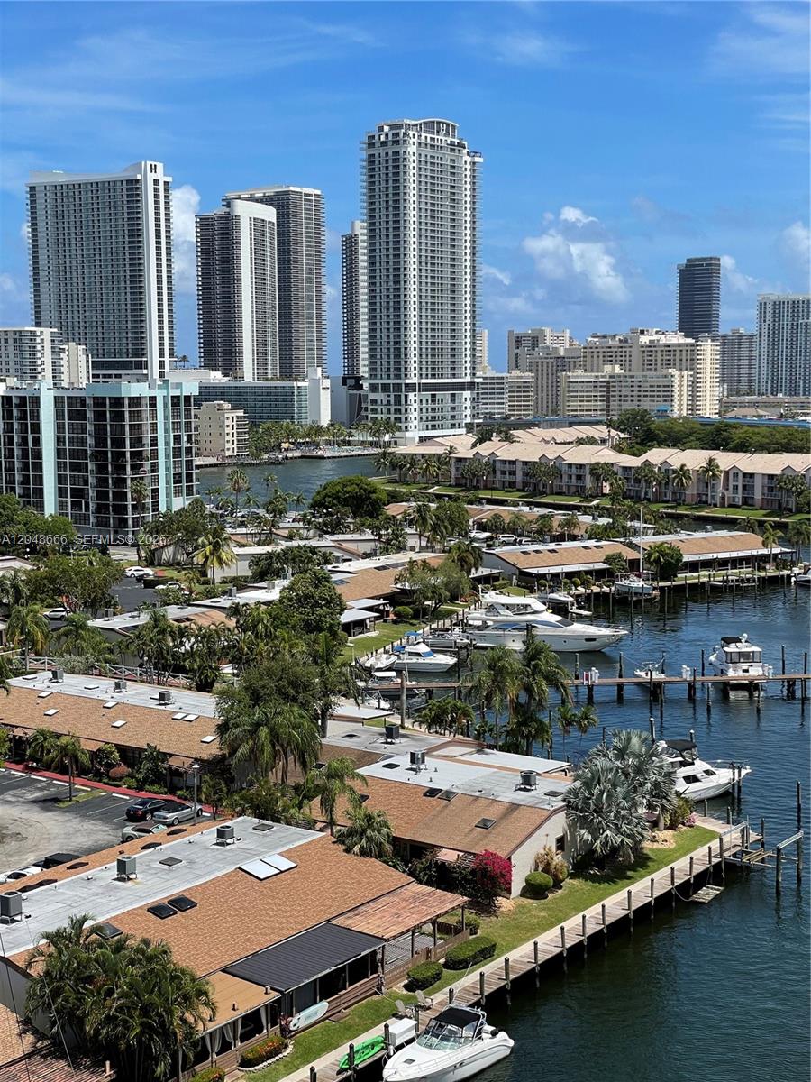 An elevated view of a canal with docked boats, residential buildings, and high-rise towers — 2500 PARKVIEW DR # 1405, Hallandale Beach FL 33009, HALLANDALE BEACH, FL