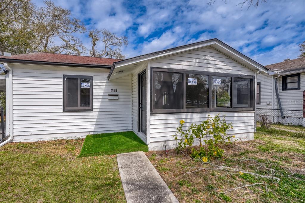 A white, single-story house with a screened-in porch and a concrete walkway — 711 19TH AVENUE S, ST PETERSBURG, FL