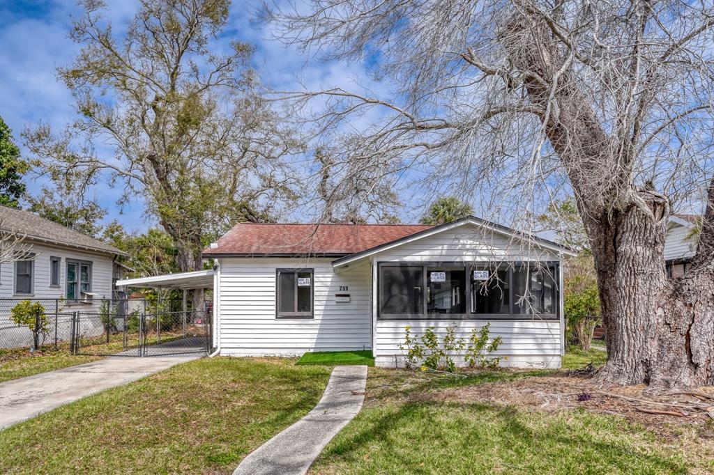 A white, single-story house with a carport, a front porch, and a concrete walkway — 711 19TH AVENUE S, ST PETERSBURG, FL