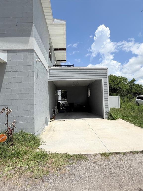 An exterior view shows a concrete block building with an open-air carport and driveway — 3180 LINCOLN STREET, SANFORD, FL