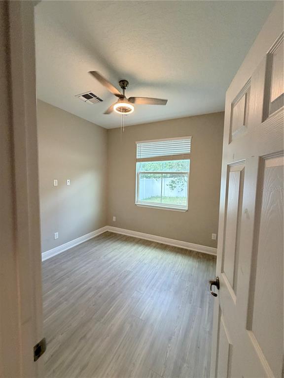 A bedroom with light-colored walls, wood-look flooring, a ceiling fan, and a single window — 3180 LINCOLN STREET, SANFORD, FL