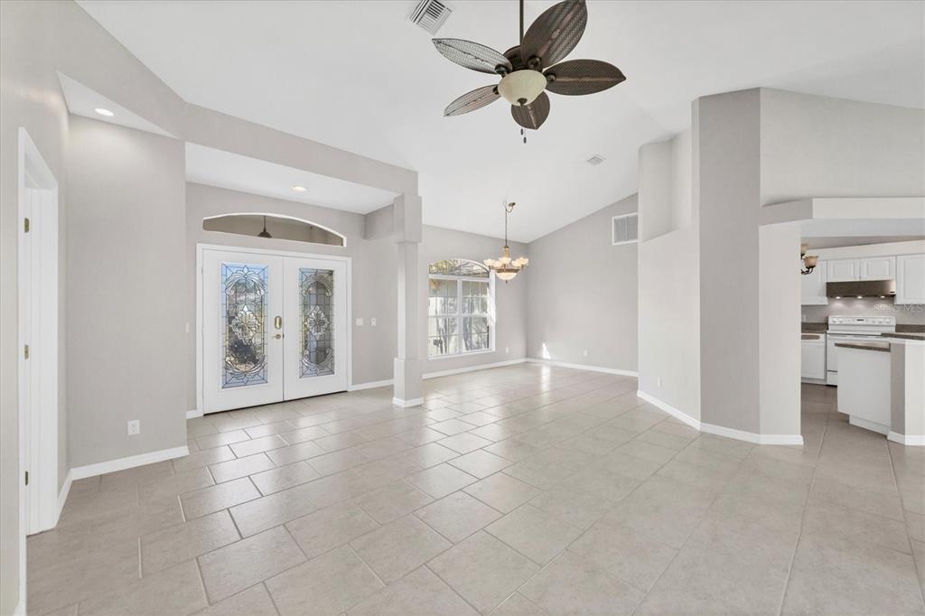 An open-concept living area features light gray walls, tile flooring, and a ceiling fan — 1236 NATRONA DRIVE, NORTH PORT, FL