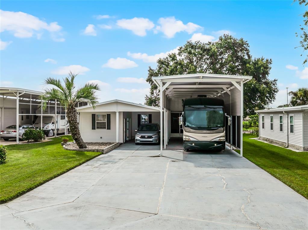 A single-story house with a carport, a large RV shelter, and a paved driveway — 5001 MOUNT OLIVE SHORES DRIVE, POLK CITY, FL