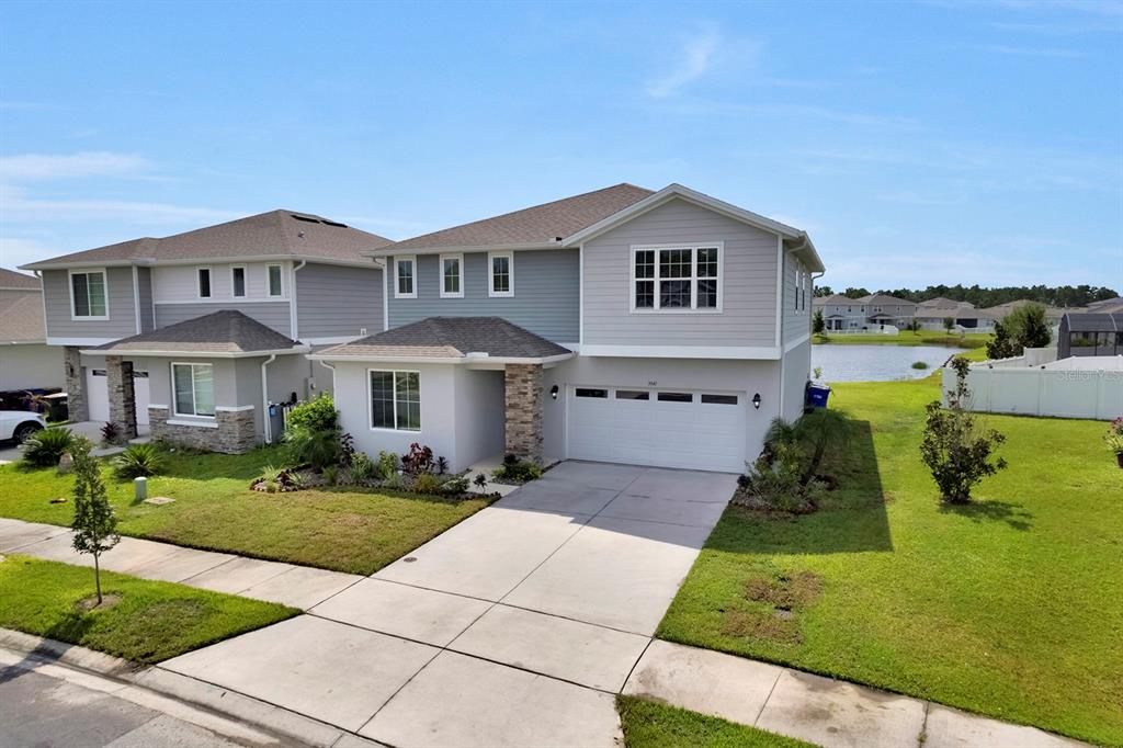 A two-story suburban house with a gray exterior, a two-car garage, and a pond view — 3941 SOUTHERN VISTA LOOP, ST CLOUD, FL