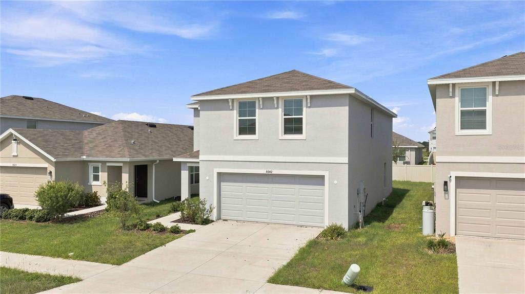 A two-story house with a light gray stucco exterior and a two-car garage — 8642 SW 46TH AVENUE, OCALA, FL