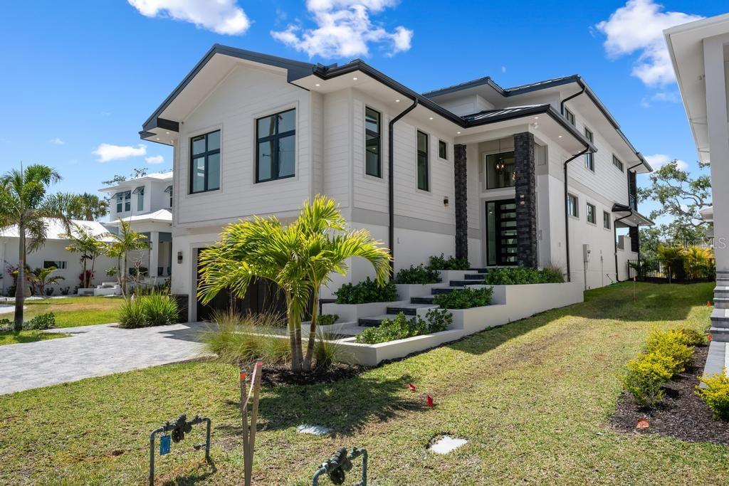 A modern two-story house with white siding, dark trim, and a stone-accented entryway — 527 VENICE LANE, SARASOTA, FL