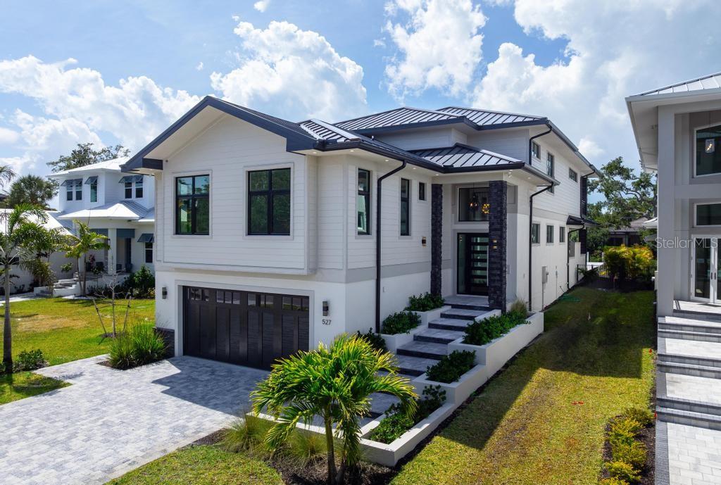 A modern two-story house with a metal roof, white siding, and a stone-accented entryway — 527 VENICE LANE, SARASOTA, FL